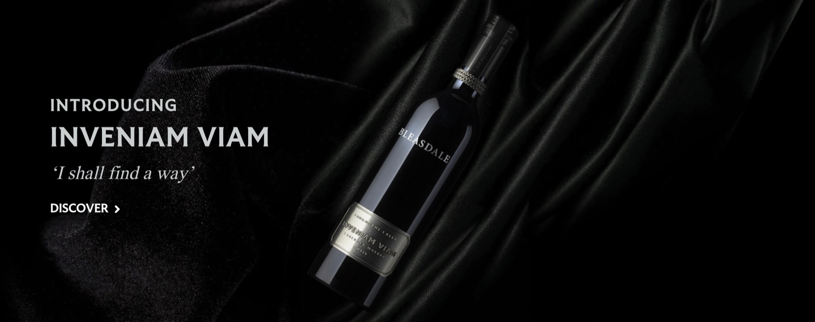 Inveniam Viam 官方发布横幅——酒瓶置于深色绸缎之上